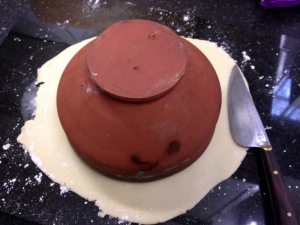 The pastry case being cut out using a 'suitable' bowl and knife!